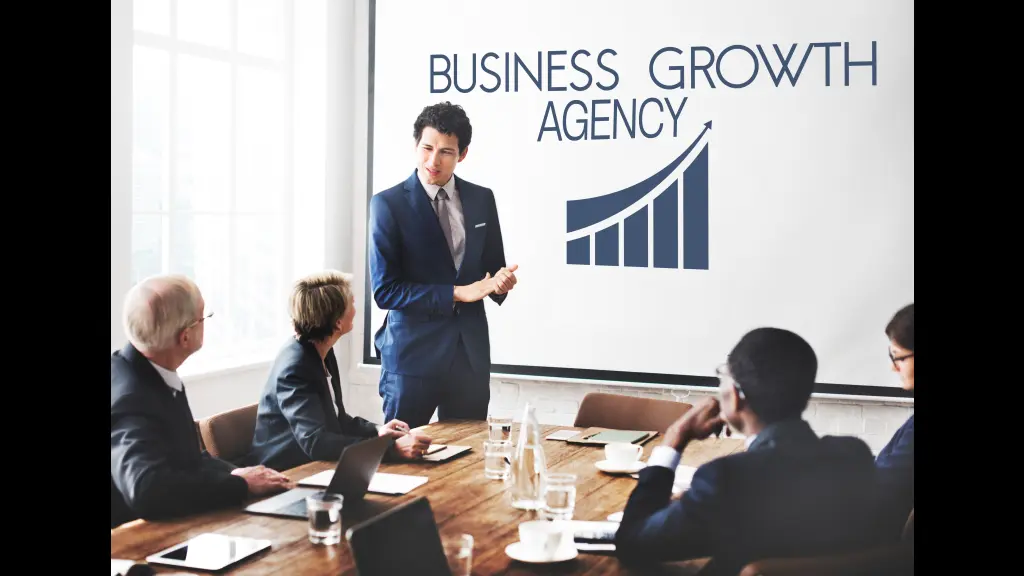 Business team discussing growth strategy during a presentation in a meeting room.