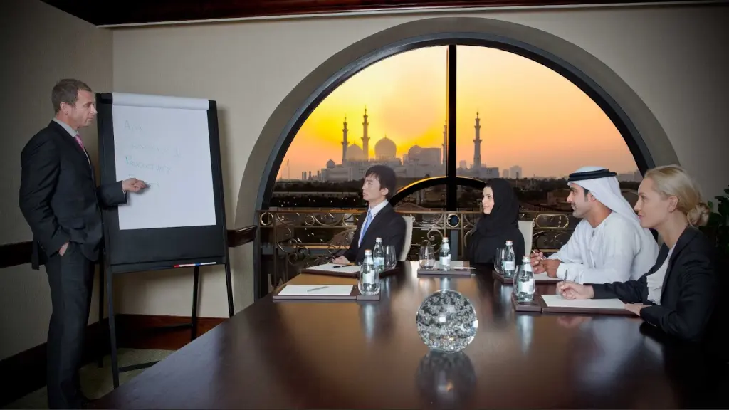 Business professionals in a UAE meeting discussing strategy with city skyline view.